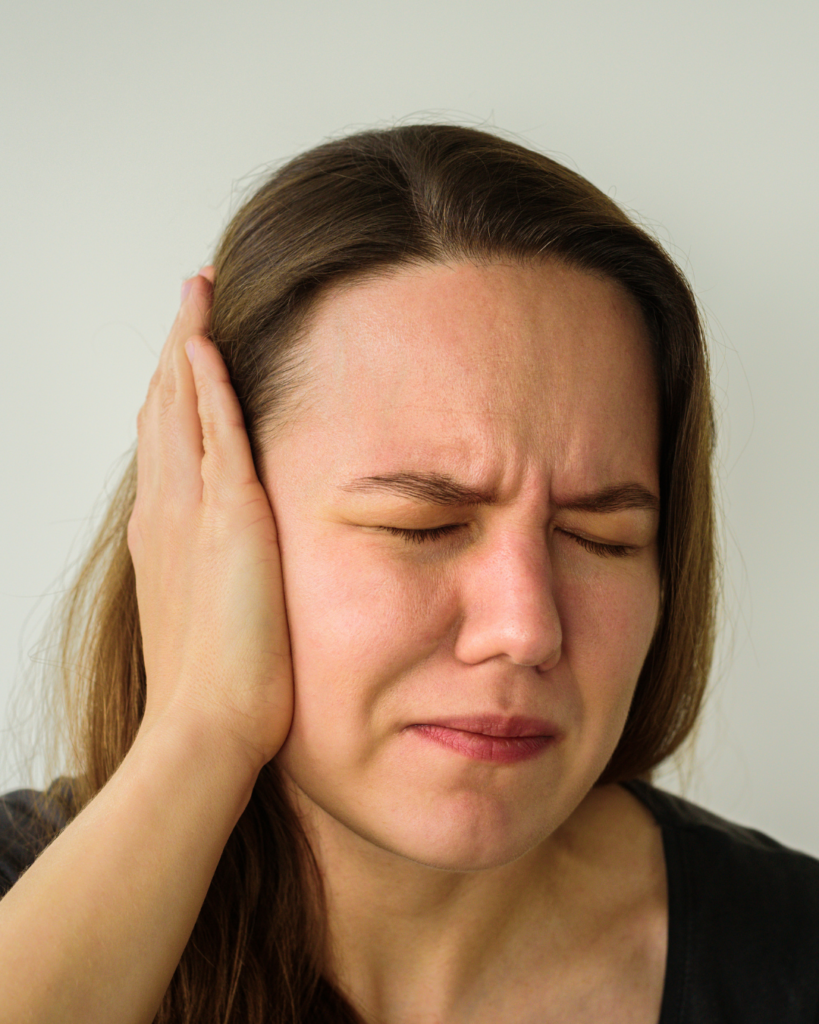 ρήξη τυμπάνου woman covering ear in pain